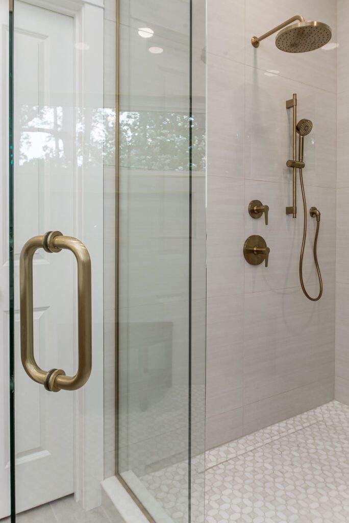 brushed bronze hardware on heavy glass shower for a bathroom remodel project 
